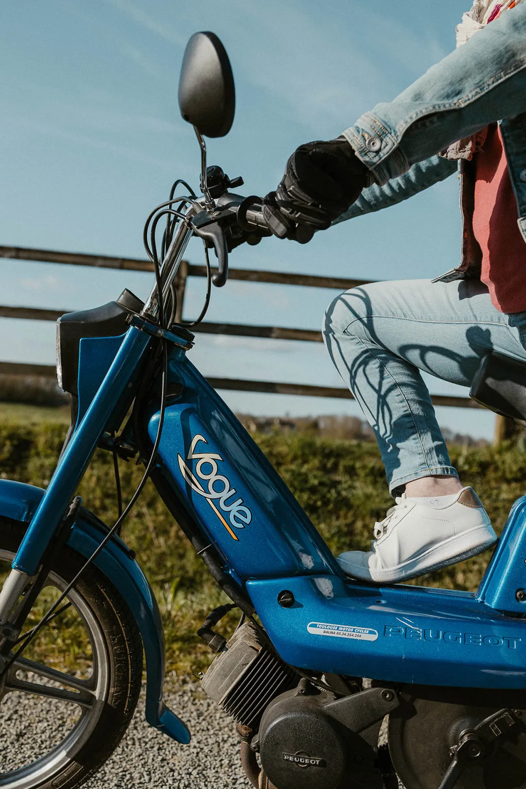 Photo d'une Peugeot 103 Vogue bleue représentant un bon cadeau pour la location en Bretagne, en Normandie, à Cherrueix, à Brocéliande, à la Roche aux Fées, pour des balades originales, du team building, des cousinades, EVG/EVJF, en Baie du Mont Saint-Michel, près de Saint-Malo et de Cancale
